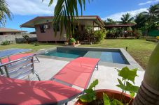 Bungalow de alquiler en la península de Tahití con piscina La vista de la piscina, el bungalow y el jardín