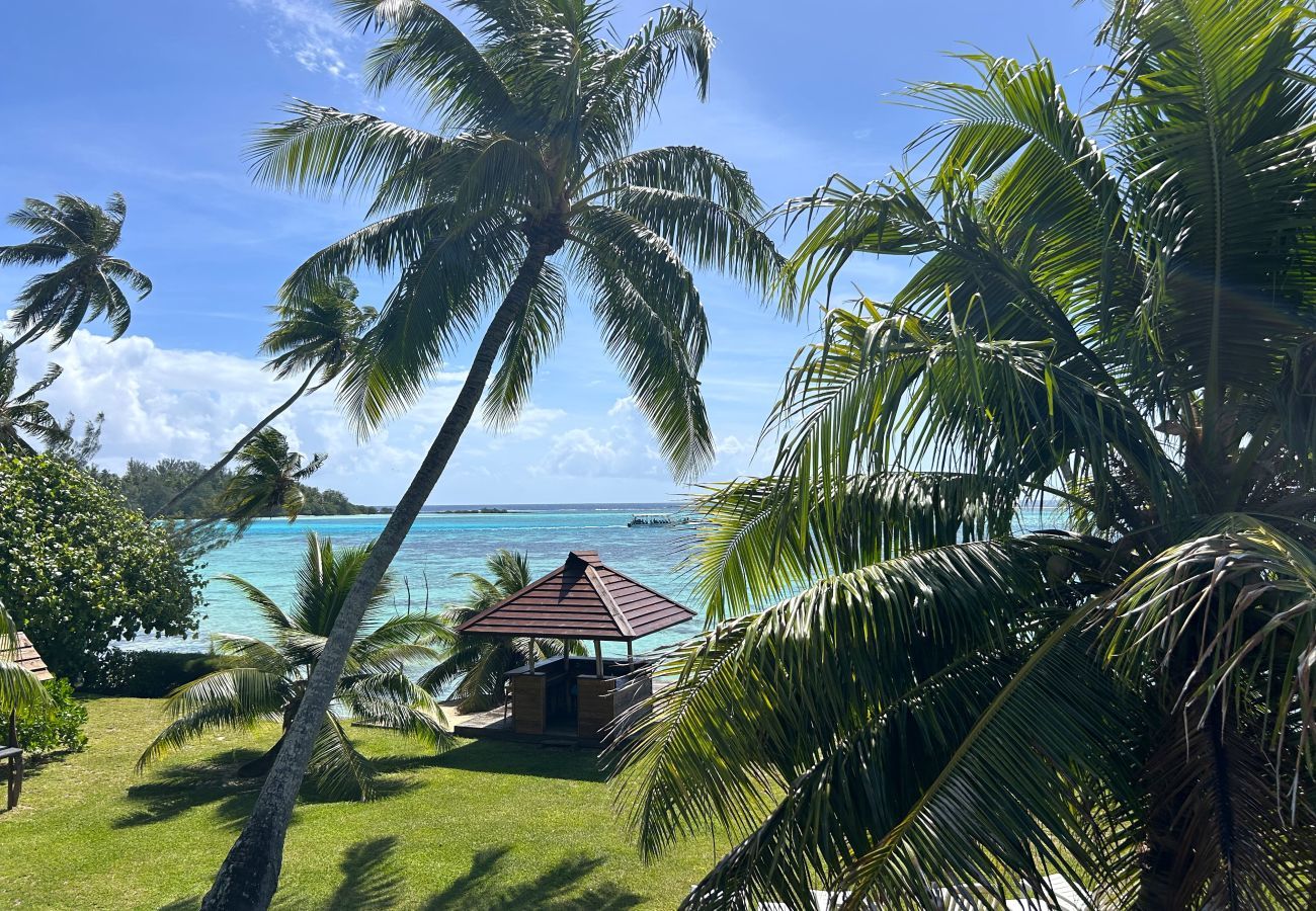 View from the villa mezzanine over a tropical garden, Moorea's turquoise lagoon and the Fare Pote'e