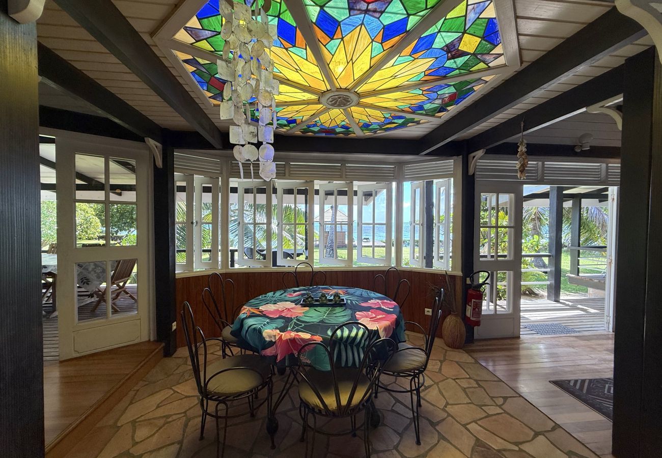 Elegant table beneath a stunning stained-glass ceiling, reflecting sunlight and casting colourful light throughout the room