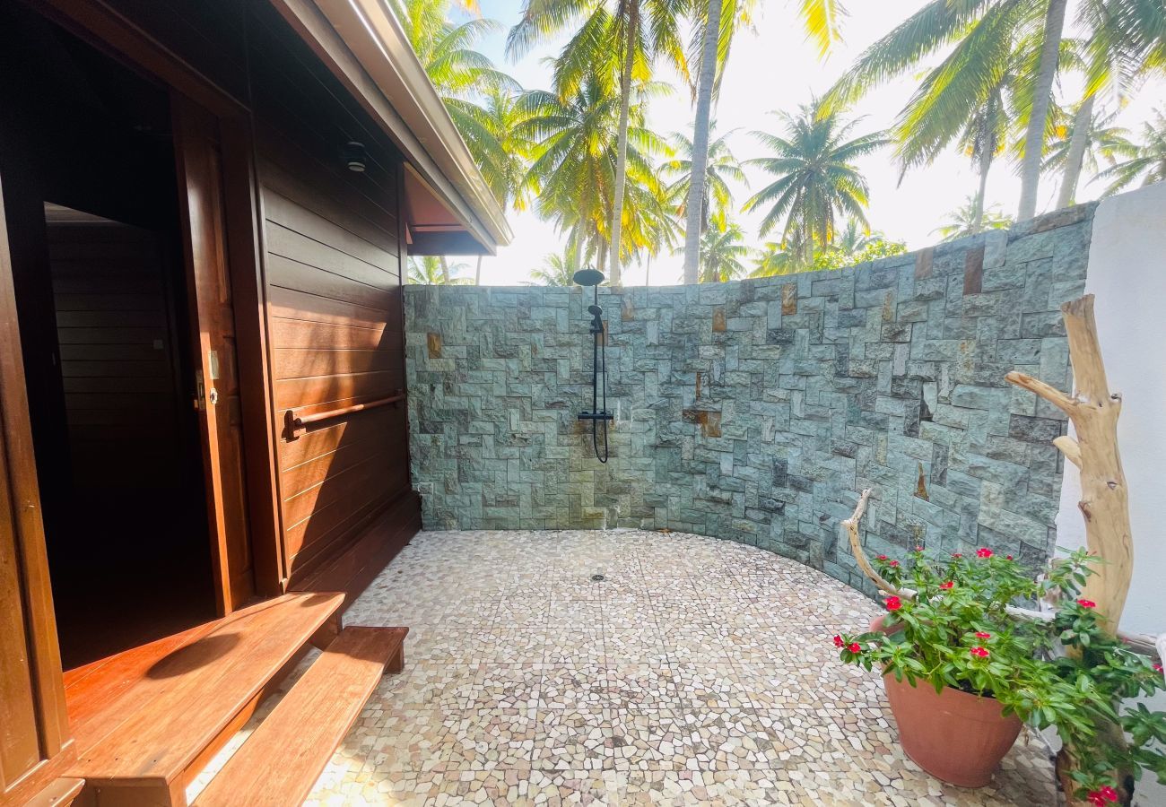 Open-air shower room in a coconut grove.