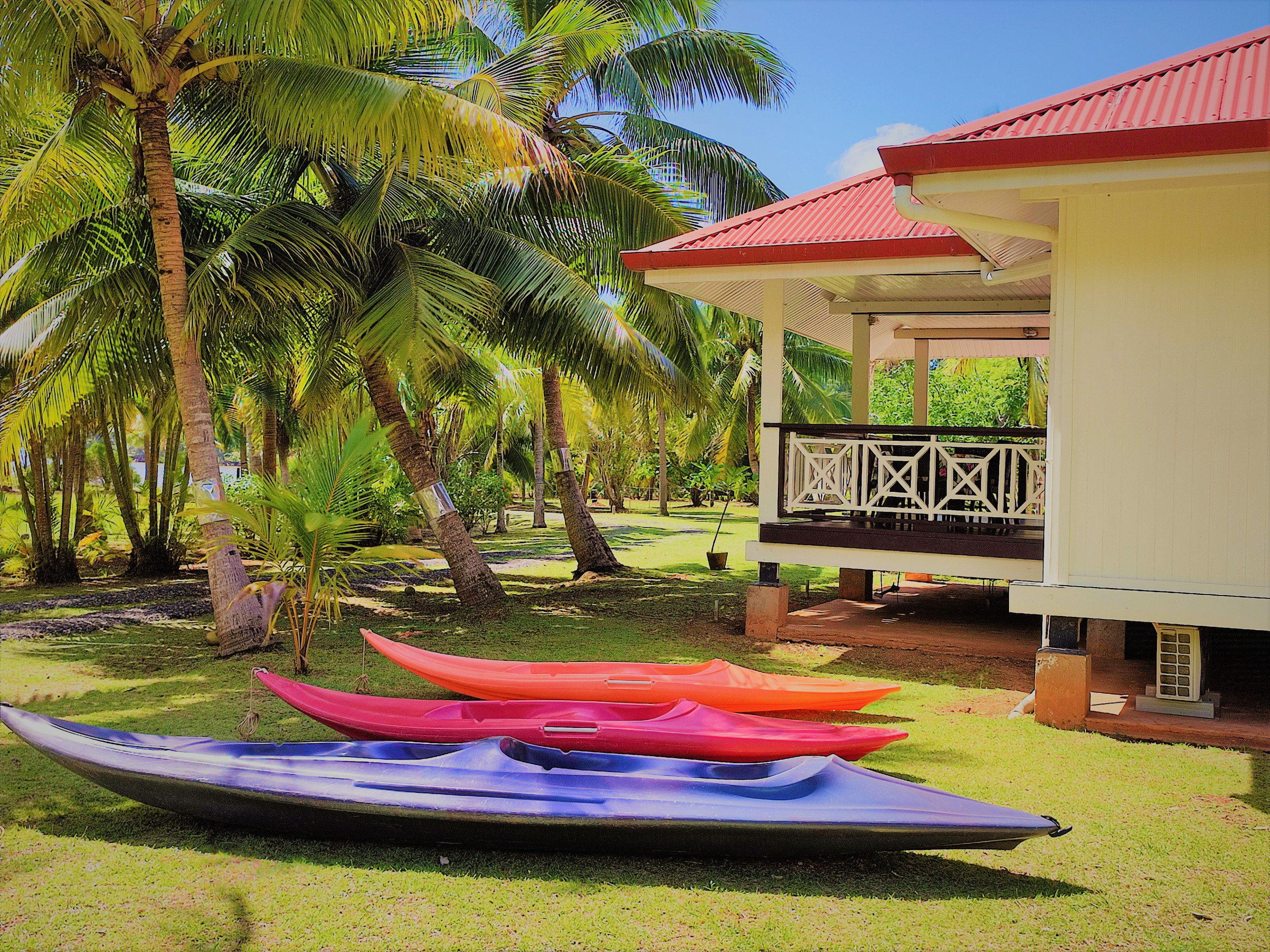 Casa de vacaciones frente al mar en Huahine, con kayaks y jardín arbolado.