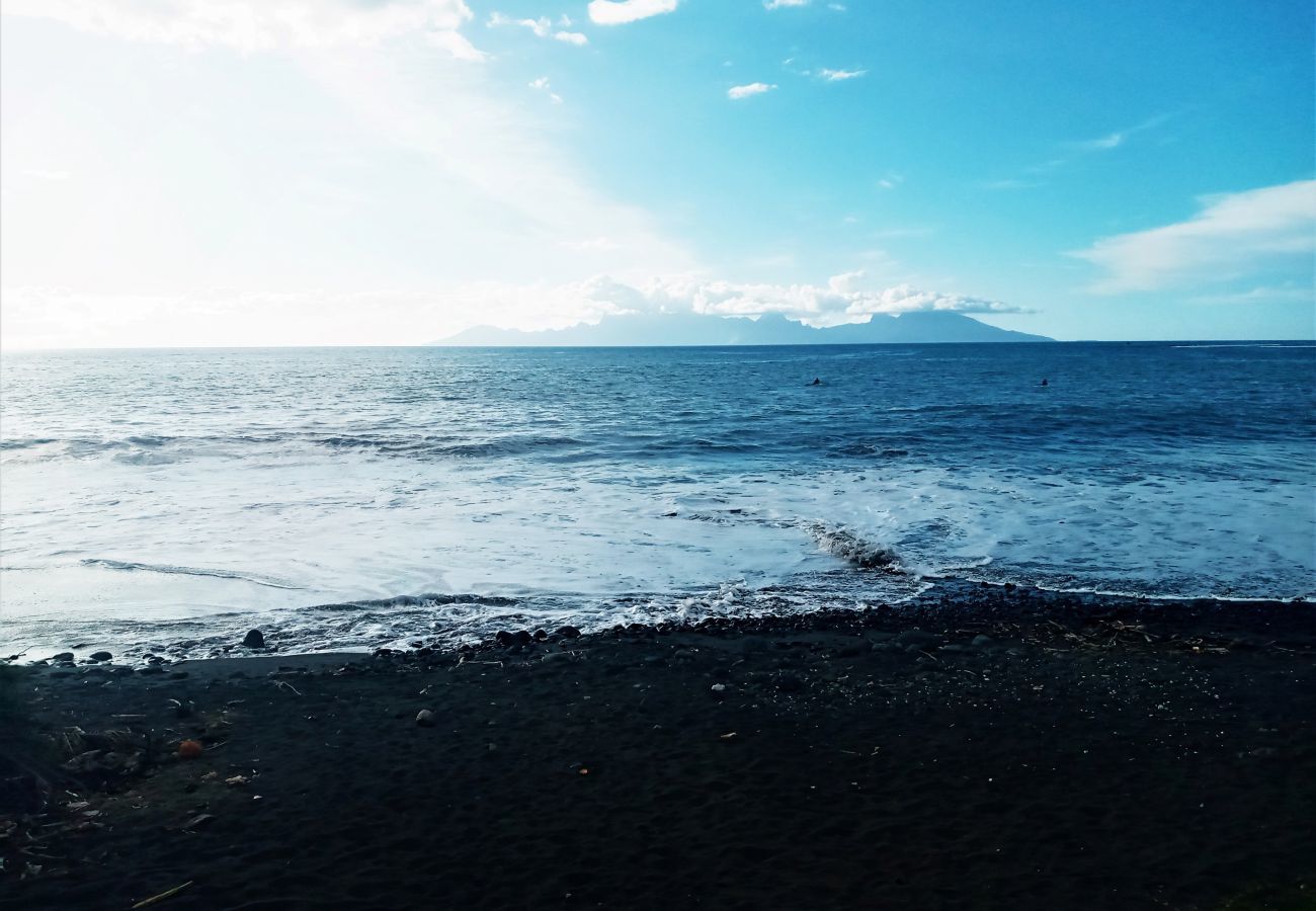 Playa de arena negra con vistas a la isla de Moorea de acceso gratuito
