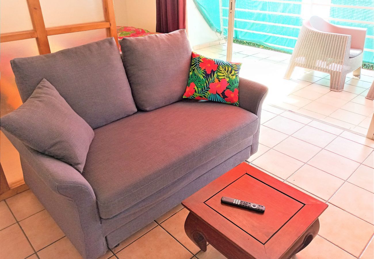 Alquilar para sus estancias en Tahití piso con salón equipado con sofá cama y televisión