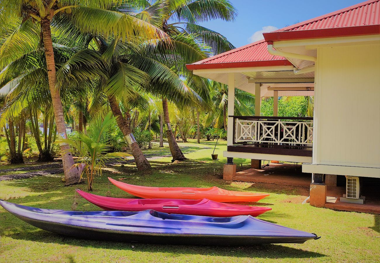 Casa de vacaciones frente al mar en Huahine, con kayaks y jardín arbolado.