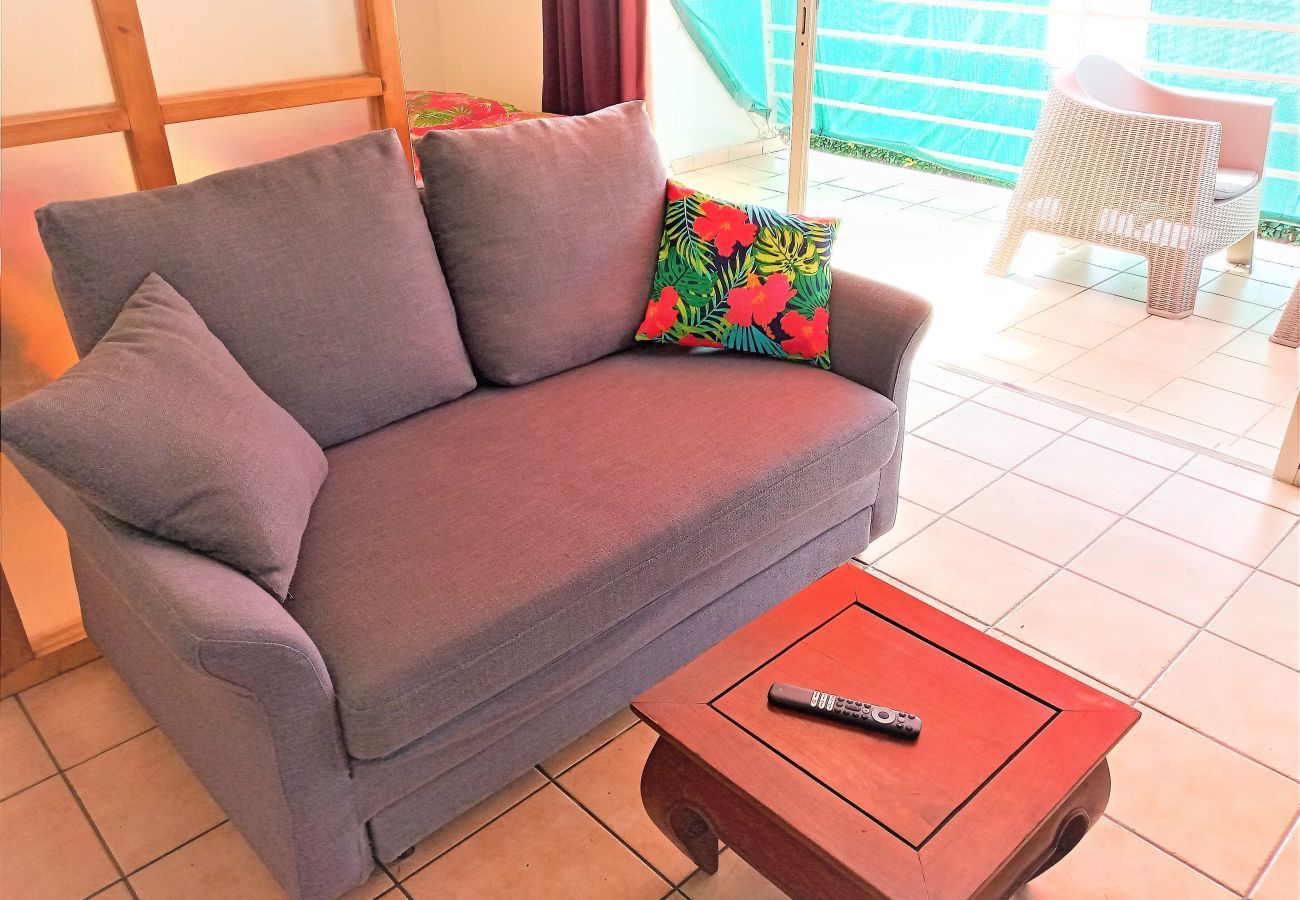 In affitto per i vostri soggiorni a Tahiti appartamento con soggiorno dotato di divano letto e televisione