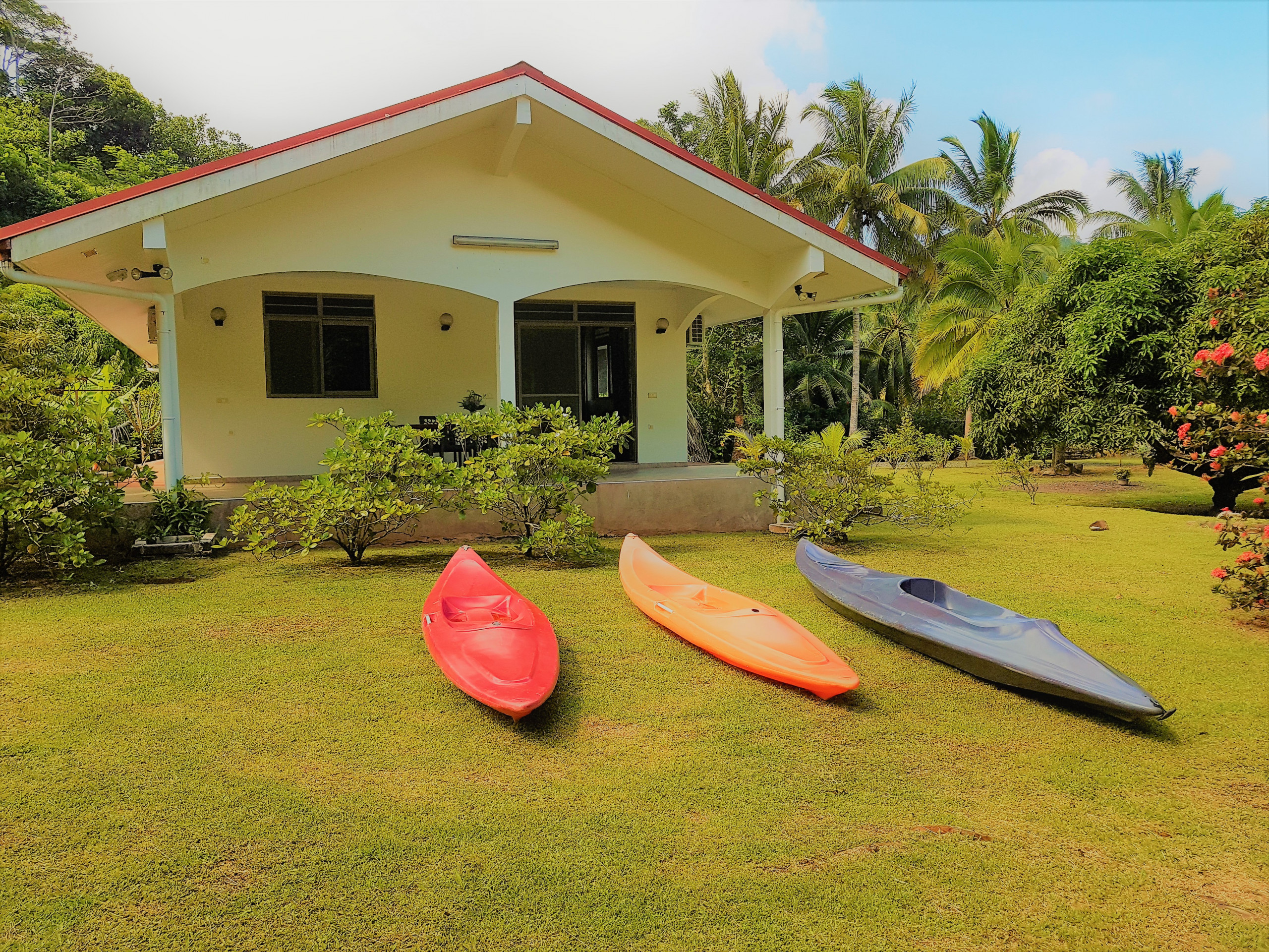 Maison de vacances à Huahine côté bord de mer, avec kayaks et jardin arboré.