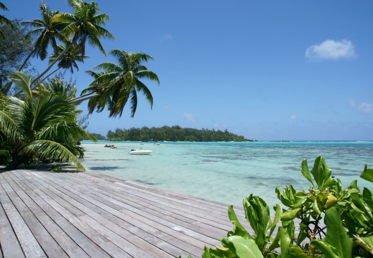 Terrasse de la Sundara Soul Villa avec vue sur le lagon transparent et les palmiers, location de vacances sur l'île de Moorea