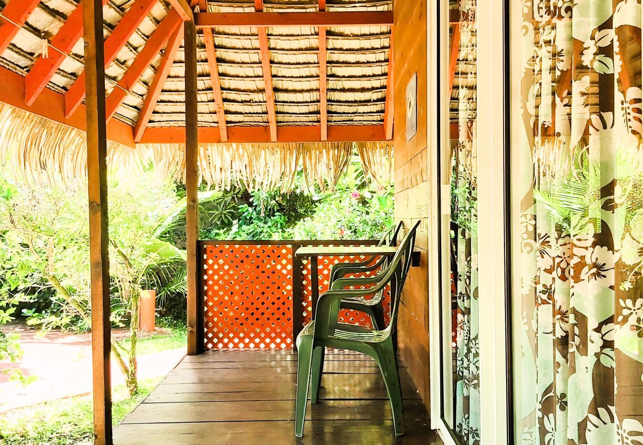 L'entrée du bungalow par la terrasse équipée d'une table et de chaises pour 2 personnes